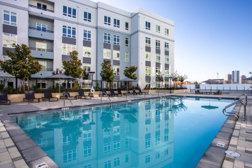 a large swimming pool in front of an apartment building