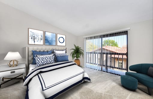 Two Bedroom Apartments in Laguna Niguel CA - Pointe Niguel - Bedroom with Carpeted Floor, Bed, Nightstand, Lamp, Chair, and Sliding Glass Door with Access to Balcony at Pointe Niguel, Laguna Niguel, C