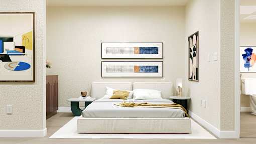 A bedroom with a bed, nightstands, and artwork on the walls at Skyview Sunset Apartments, California