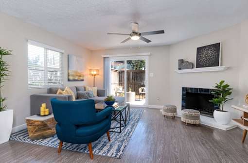 A living room with a blue chair and a fireplace at Nola 624 Apartments, California