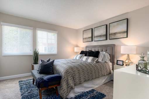 A bedroom with a large bed and a bench in front of it at Nola 624 Apartments, West Covina, 91790