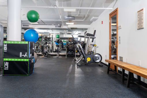 a gym with weights and cardio machines and a wooden table