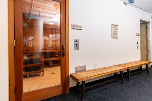 a room with a wooden bench and a glass door