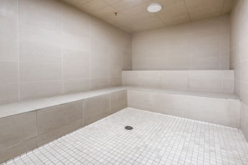 a white tiled bathroom with a shower and a tub