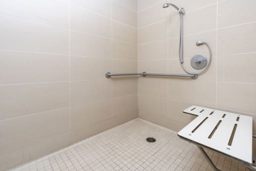 a bathroom with a shower and a stool in it