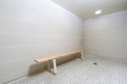 a empty room with a wooden bench in the corner
