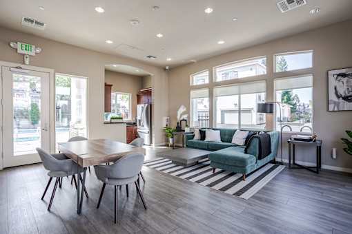 A well-lit room with a dining table and a couch.