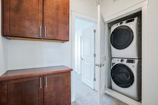 A white washing machine is in a cabinet in a room.
