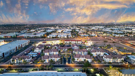 A cityscape at dusk with buildings and streets illuminated.