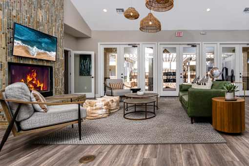 A living room with a fireplace and a painting of a beach scene on the wall.