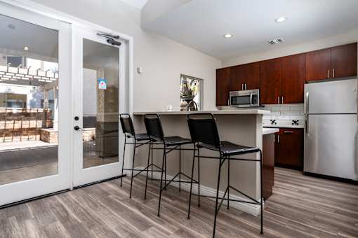 A kitchen with a bar stool and a fridge.