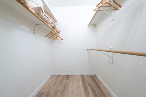 A hallway with a white wall and a wooden floor.