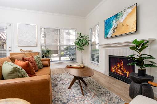 A living room with a fireplace and a painting on the wall.