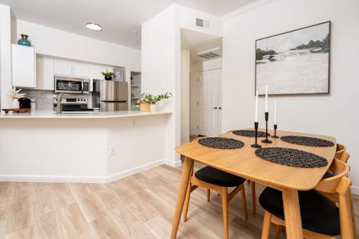 A dining room with a wooden table and chairs.