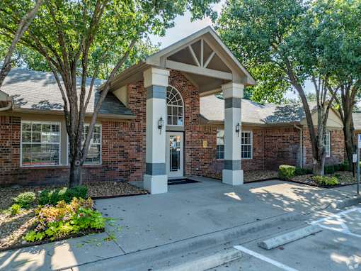 A brick building with a white door and pillars.