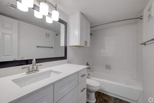 A white bathroom with a sink, toilet, and bathtub.