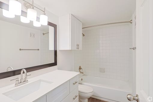 A white bathroom with a sink, toilet, and bathtub.