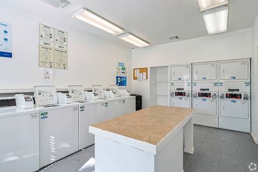 A laundromat with a row of washers and dryers.