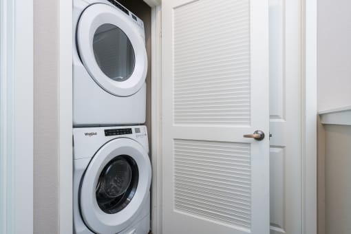 a small laundry room with a stackable washer and dryer