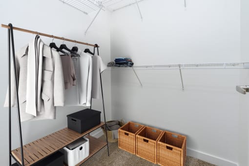 a walk in closet with wooden shelves and baskets