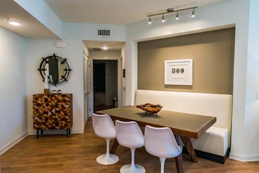 A dining room with a wooden table and white chairs. at Baker Block, California