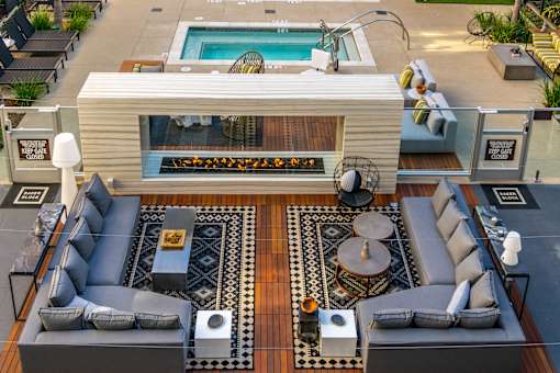 A modern outdoor living space with a pool and a fireplace. at Baker Block, California