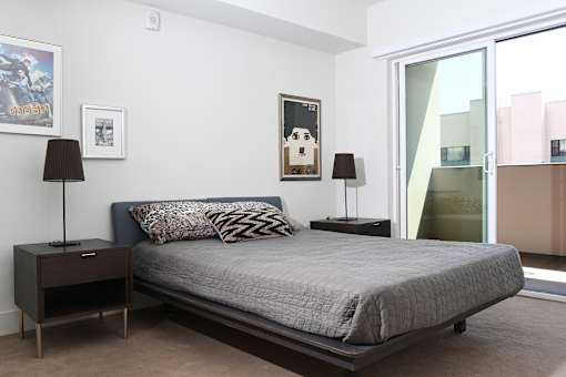 A bedroom with a bed, nightstands, and a poster on the wall at Wilshire Valencia Apartment, Los Angeles, 90017