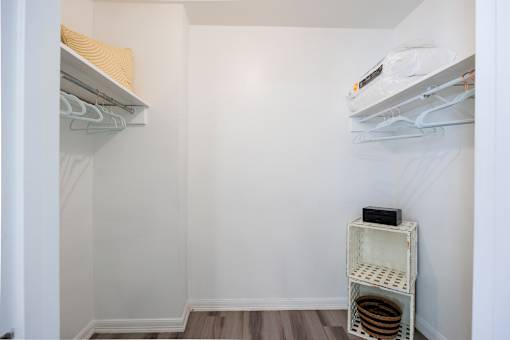 A small white closet with a shelf and a hanging rod.