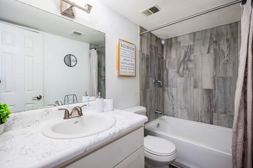 A bathroom with a white sink and a white toilet.