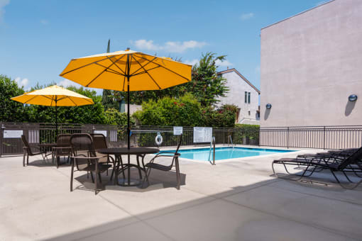 our apartments have a pool and a patio with chairs and umbrellas