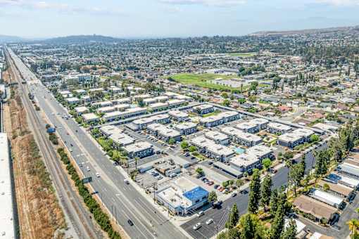 A highway runs through a city with apartment buildings on either side.