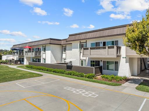 A building with a basketball court in front of it.