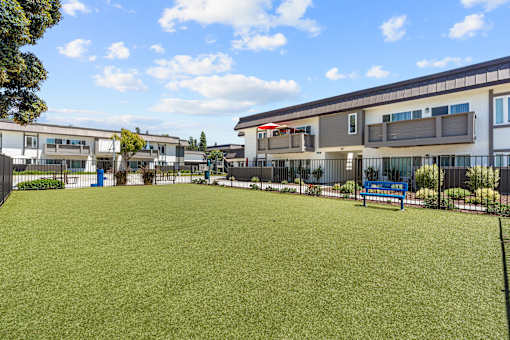 A grassy field in front of a building with a blue sign.