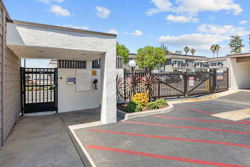 A parking lot with red lines and a black gate.