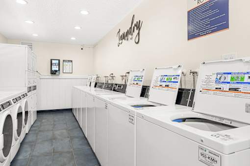 A laundry room with washing machines and a sign that says "Laundry".