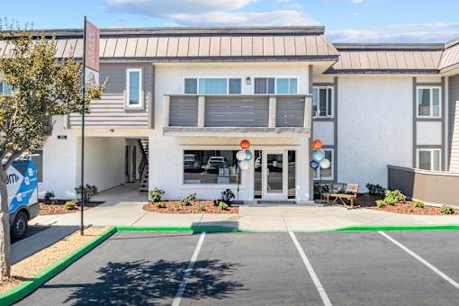 A modern building with a parking lot in front.
