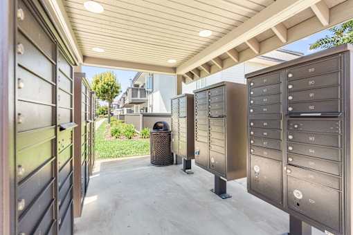 A row of mailboxes are lined up on a sidewalk.