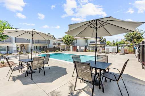 A patio with a table and chairs and an umbrella.