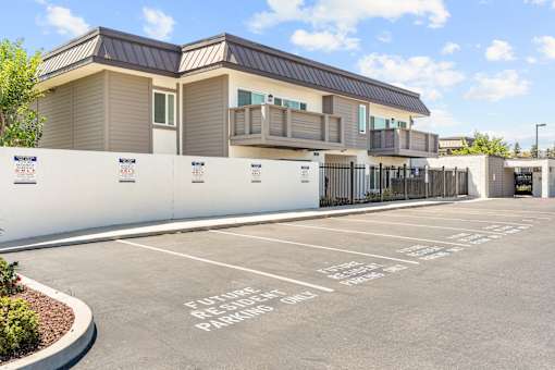 A parking lot in front of a building with a sign that says "Estate Resident Parking".
