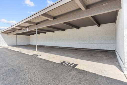 A parking garage with a concrete floor and a white wall.