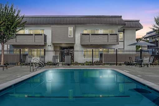 A modern house with a pool in front.