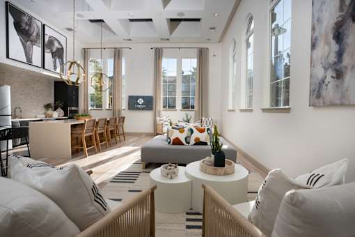 A modern living room with a kitchen area in the background at Capriana at Chino Hills, California, 91709
