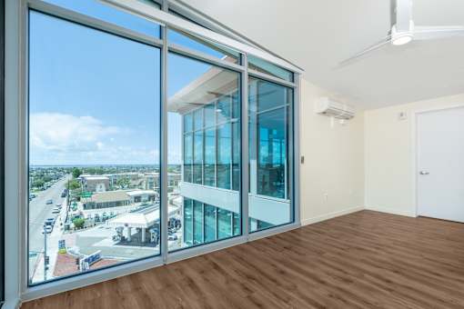 A room with a view of the street outside through large windows.