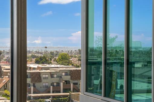 A view from a window looking out at apartment buildings and trees.