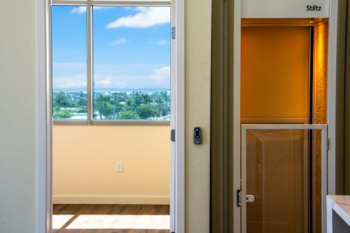 A room with a window and a door with a handle.