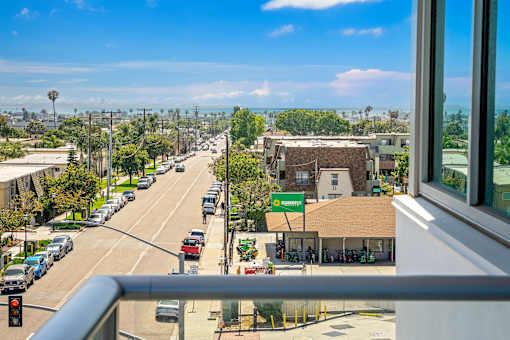A view from a window of a street with cars and a green sign that says "QuikTrip".