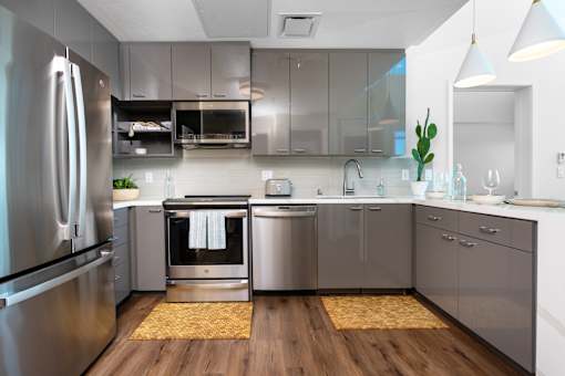 A modern kitchen with stainless steel appliances and wooden floors.