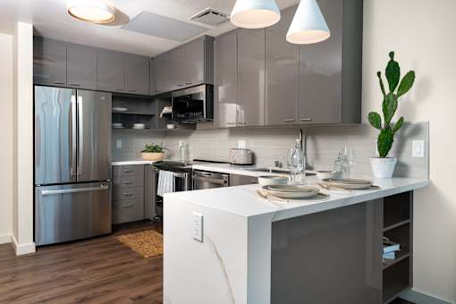 A modern kitchen with a white island and stainless steel appliances.