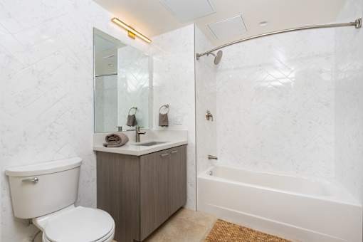 A white bathroom with a toilet, sink, and bathtub.