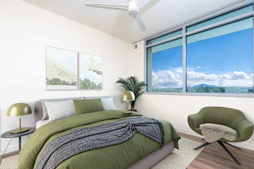 A bedroom with a large bed and a green chair.